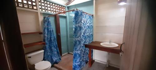 a bathroom with a sink and a shower curtain at La Mariola - Finca Agroecológica in El Castillo de La Concepción