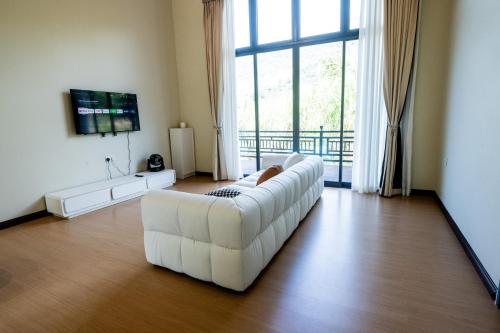 un sofá blanco en una sala de estar con una gran ventana en 929 Villa en Ranau
