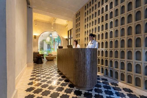 two people sitting at a reception desk in a lobby at Cinco Quintas Hotel Boutique By SOHO in Cartagena de Indias
