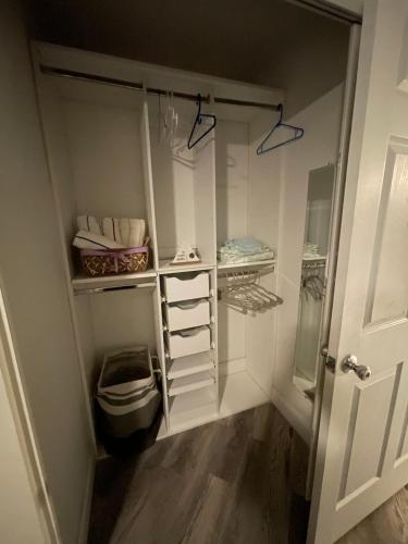 ein begehbarer Kleiderschrank mit weißen Schränken und einer Tür in der Unterkunft Bacolet Beach Luxe Pool Cottage in Palm Beach Gardens