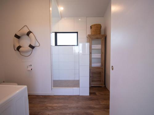 uma casa de banho com um chuveiro e uma porta de vidro em The Boat House On Dixon em Oakura