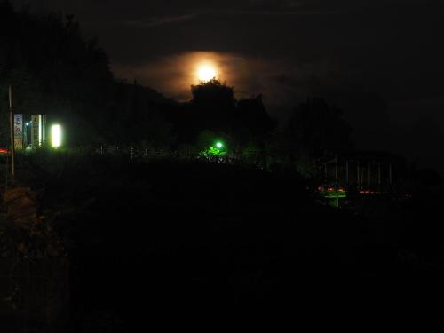 a night view of a city with the moon in the background at SunRise 23.5N B&B in Fenchihu
