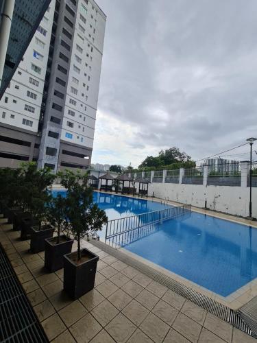 ein großer Pool neben einem hohen Gebäude in der Unterkunft Cozy Casa Idaman Home for Muslim Family by Nina in Kuala Lumpur