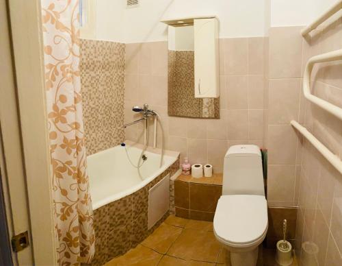 a bathroom with a toilet and a bath tub at Like Home Apartments in Almaty