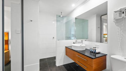 uma casa de banho branca com um lavatório e um espelho em Sea Side 411 em Mandurah