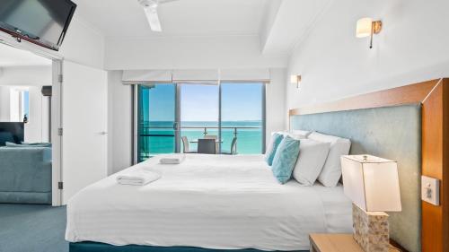 a bedroom with a large bed with a view of the ocean at Sea Side 411 in Mandurah