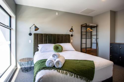 a bedroom with a large bed with towels on it at THE Residence Apartment 8 50 Sky in New Plymouth