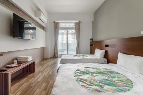 Habitación de hotel con 2 camas y TV en 自由之丘民宿 l 寵物友善, en Taitung