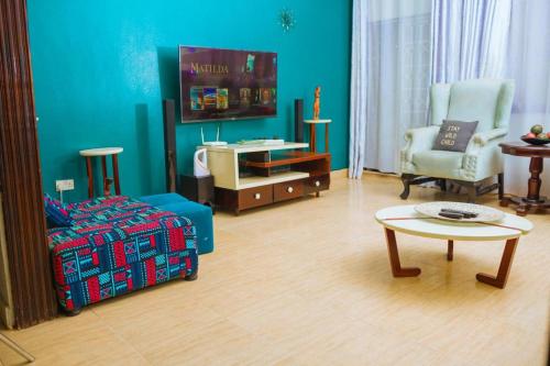 ein Wohnzimmer mit einem Sofa und einem Tisch in der Unterkunft City Oasis Home Stays by Siima in Kampala