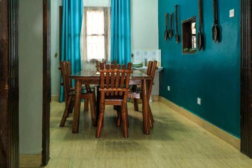 a dining room with a wooden table and chairs at City Oasis Home Stays by Siima in Kampala