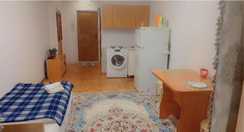 a kitchen with a refrigerator and a washing machine at Like Home Apartments in Almaty