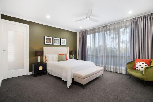 a bedroom with a white bed and a window at Cicada Close Hideaway in Buderim
