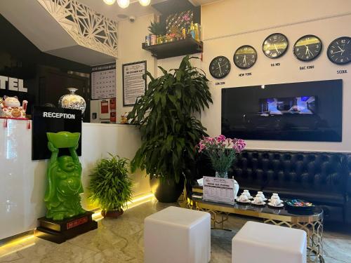 sklep z zegarami na ścianie i kanapą w obiekcie Sky Hotel w mieście Bắc Giang