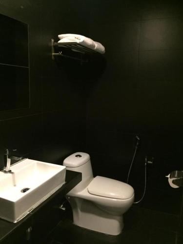 a bathroom with a white toilet and a sink at Ryokan Chic Hotel in Petaling Jaya
