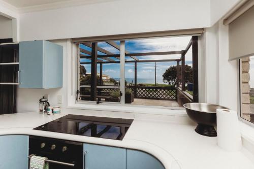 a kitchen with a counter with a sink and a window at Blue Haven On Belt Waterfront in New Plymouth