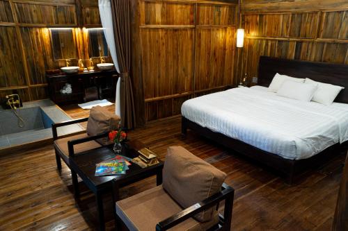 1 dormitorio con 1 cama, 1 mesa y 1 habitación en Thai Hai Village - Bản làng Thái Hải, 