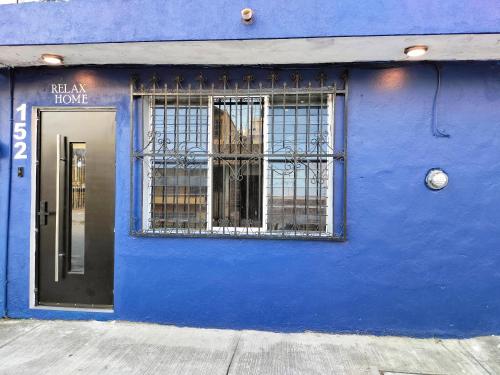 un bâtiment bleu avec une porte et une fenêtre dans l'établissement Relax Home Aeropuerto, à Chetumal