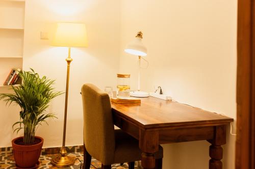a wooden table with a chair and a lamp at Luho C 7 in Bengaluru