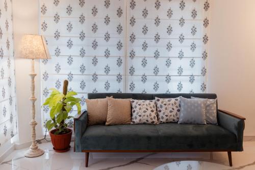 a green couch in a living room with a blue wall at Luho C 7 in Bengaluru