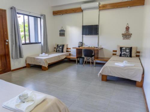 Una habitación con dos camas y una mesa dentro. en Tamarind, en Panglao
