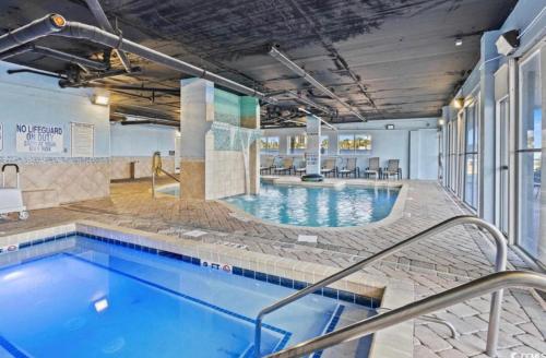 a swimming pool in a building with a hotel at Ocean Pearl at Atlantica in Myrtle Beach