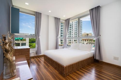 een slaapkamer met een bed en een groot raam bij Convinia Luxury Starhill in Ho Chi Minh-stad
