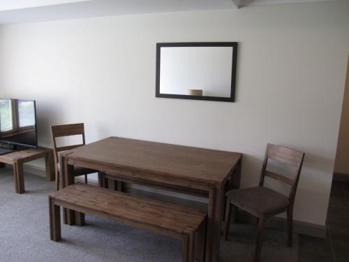 a wooden table and chairs and a mirror on a wall at Smiggins Hotel & Chalet Apartments in Perisher Valley