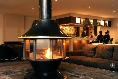 a lamp in a living room with a fireplace at Smiggins Hotel & Chalet Apartments in Perisher Valley