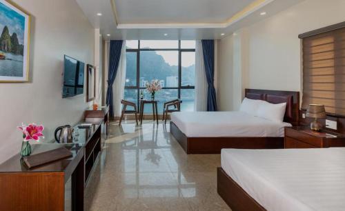 Aroma Cat Ba Sea View Hotel في كات با: غرفة فندقية بسريرين وطاولة