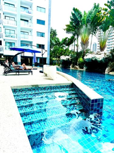 a swimming pool in front of a building at Club Royal Apartments in North Pattaya