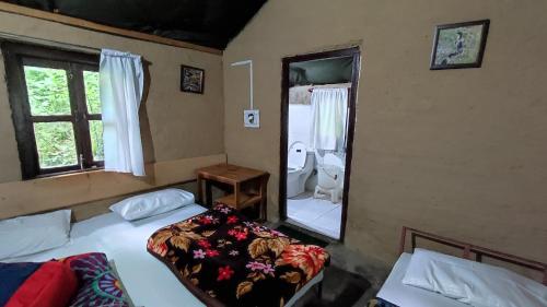 a bedroom with two beds and a bathroom with a toilet at Hail Himalayas in Chail