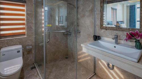 y baño con aseo, lavabo y ducha. en Aroma Cat Ba Sea View Hotel, en Cat Ba