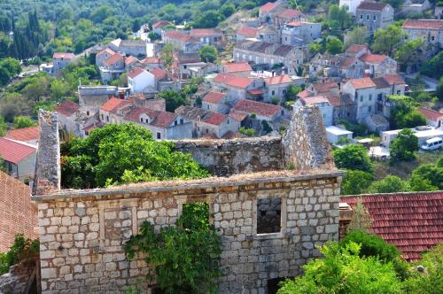 an old stone building with a town in the background at Apartments Livia in Lastovo