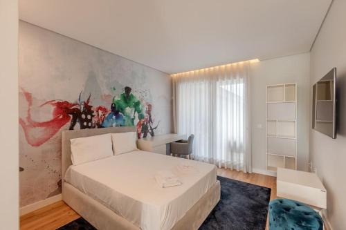 ein Schlafzimmer mit einem weißen Bett und einem Gemälde an der Wand in der Unterkunft Luxurious 5 bedrooms and with pool in Fernão Ferro