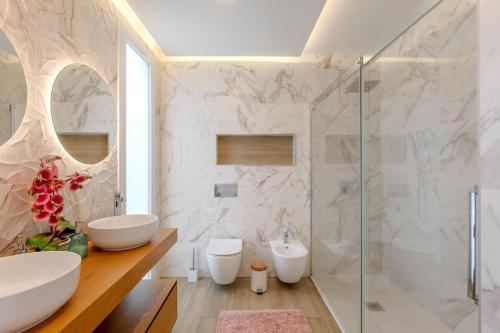 ein weißes Bad mit 2 Waschbecken und einer Dusche in der Unterkunft Luxurious 5 bedrooms and with pool in Fernão Ferro