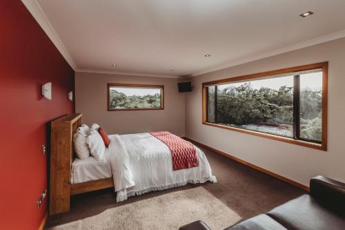 a bedroom with a bed and a large window at Serenity Lodge Getaway in Egmont Village