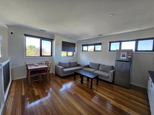 a living room with a couch and a table at Maruve Guesthouse 12 min from Melb airport in Melbourne