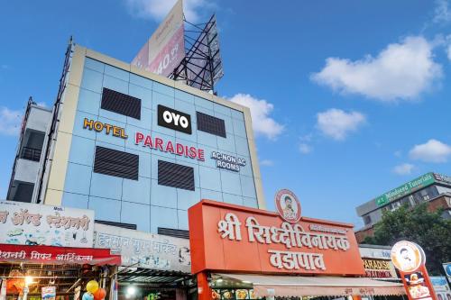 een gebouw met borden erop in een stad bij OYO Hotel Paradise in Pune