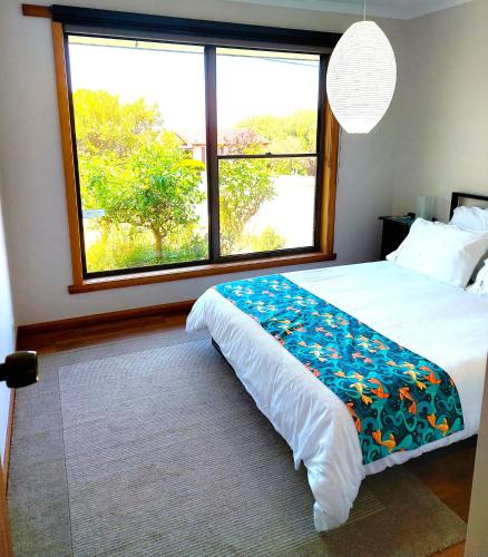um quarto com uma cama e uma grande janela em Percy's Cottage em Devonport