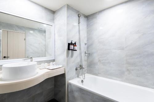 a white bathroom with a sink and a shower at Etung Hotel in Taichung