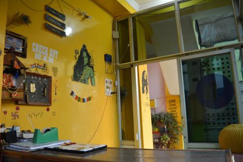 a room with a yellow wall with stickers on it at Hostel shivshakti khajuraho in Khajurāho