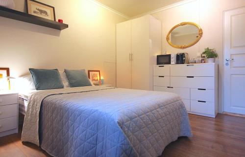 Schlafzimmer mit einem Bett, einer Kommode und einem Spiegel in der Unterkunft Førde sentrum - Lindbøen Gjesterom in Førde
