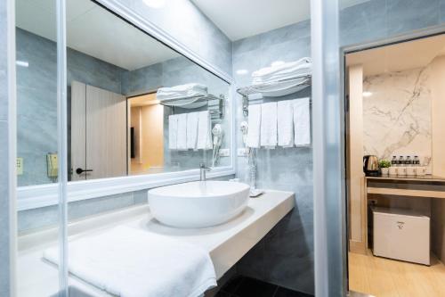 y baño con lavabo blanco y espejo. en Etung Hotel, en Taichung