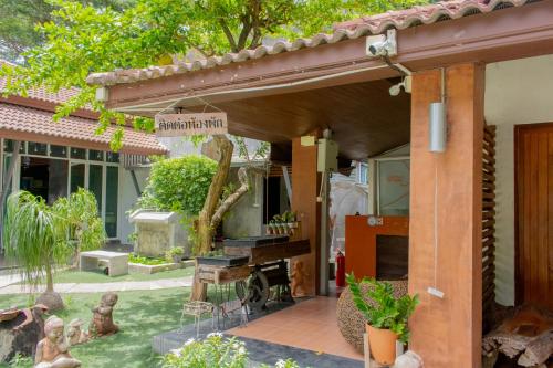 an outdoor patio with awning and a garden at Namsai Resort Kanchanaburi in Kanchanaburi