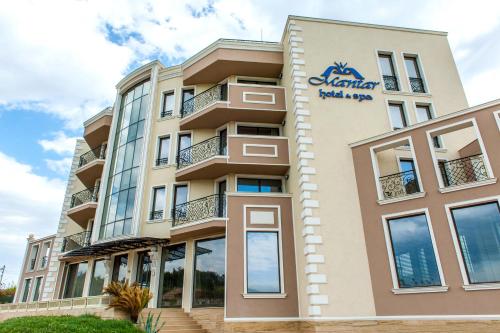 a building with a sign on the side of it at Mantar Spa Hotel in Marikostinovo