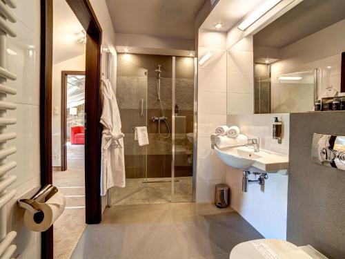 a bathroom with a glass shower and a sink at Hotel Loft 1898 in Suwałki
