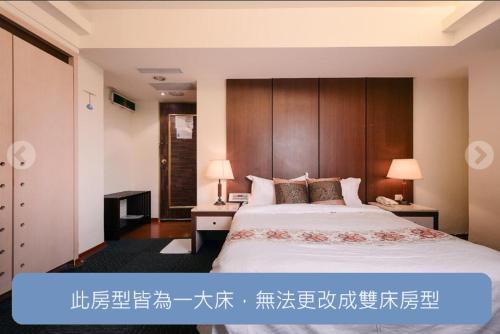 台中的住宿－華登商務大飯店，一间卧室配有一张带木制床头板的大床