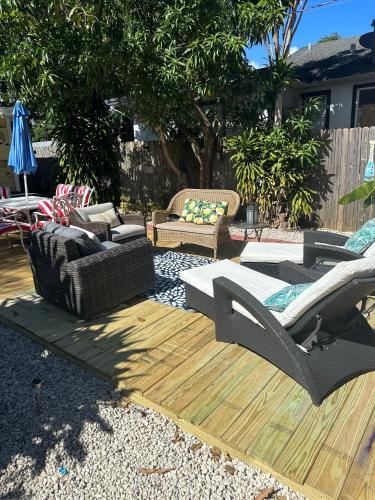 a patio with couches and chairs on a wooden deck at Mango Beach House in Lake Worth