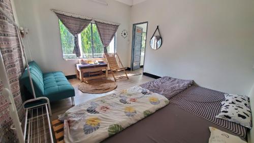 a bedroom with a bed and a chair and a table at Chú Trọc Homestay - Phan Rang Homestay & Camp in Phan Rang–Tháp Chàm
