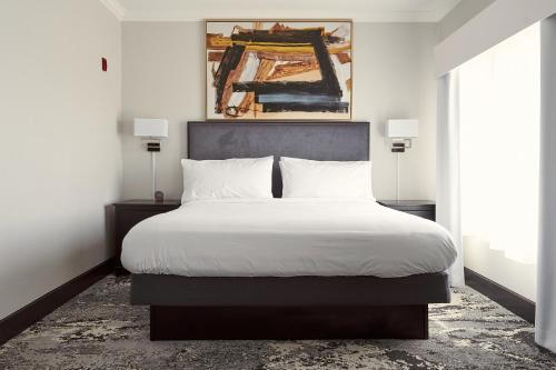 1 dormitorio con 1 cama grande con sábanas blancas en Champions Club Texas en Houston
